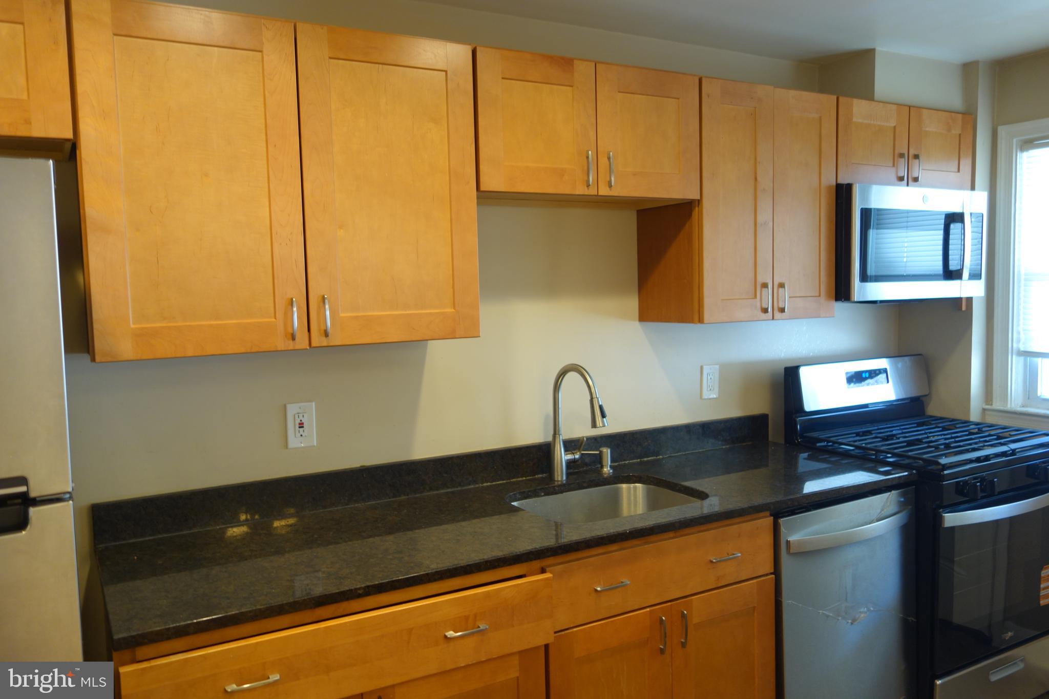 586 Lucia Avenue Baltimore, MD 21229 - Photo 4 of 14 a kitchen with granite countertop a sink a stove and cabinets