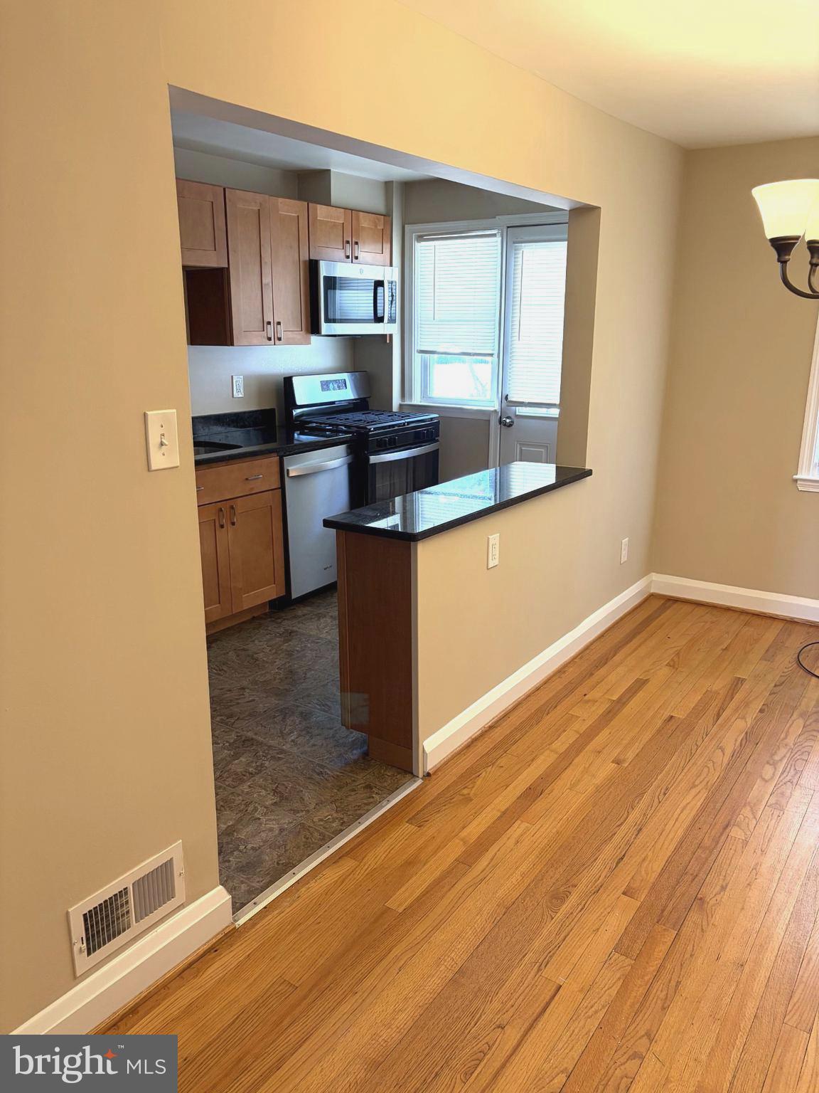 586 Lucia Avenue Baltimore, MD 21229 - Photo 6 of 14 a kitchen with stainless steel appliances granite countertop a stove a sink and a microwave