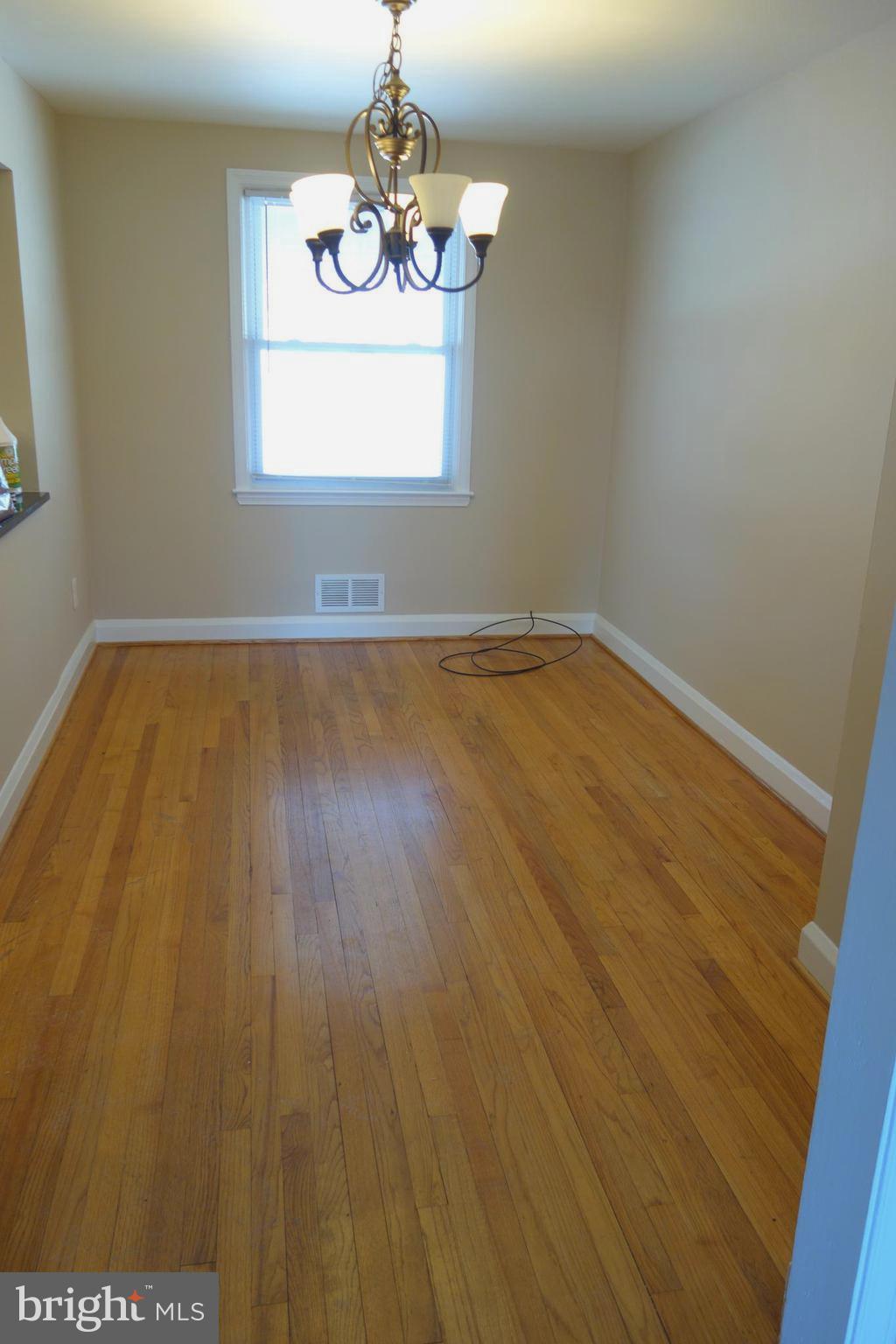 586 Lucia Avenue Baltimore, MD 21229 - Photo 7 of 14 an empty room with wooden floor and windows