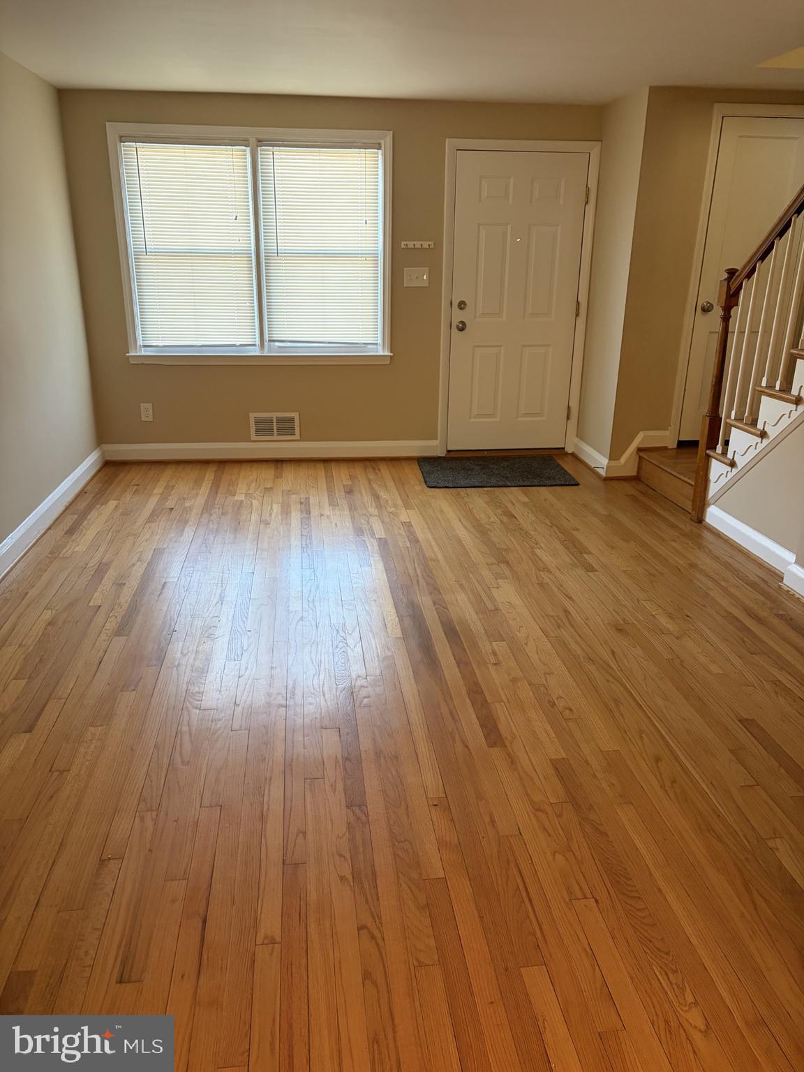 586 Lucia Avenue Baltimore, MD 21229 - Photo 8 of 14 an empty room with wooden floor and a window
