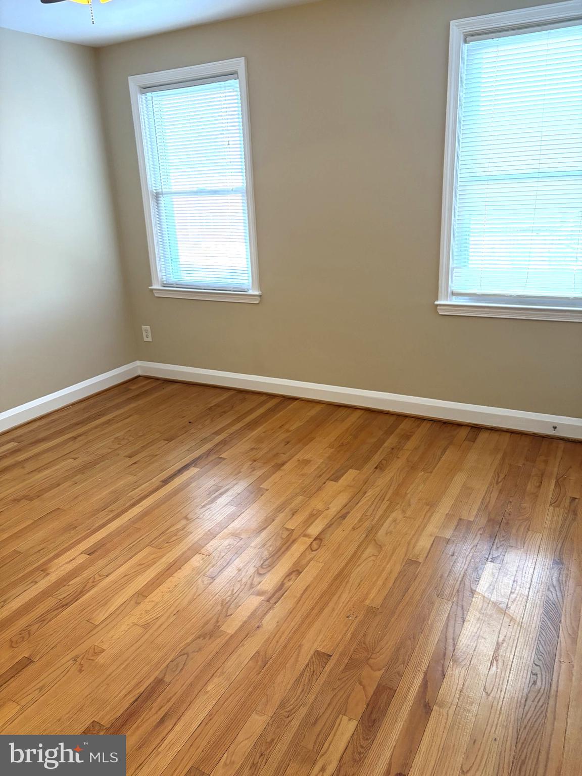 586 Lucia Avenue Baltimore, MD 21229 - Photo 9 of 14 an empty room with wooden floor and windows