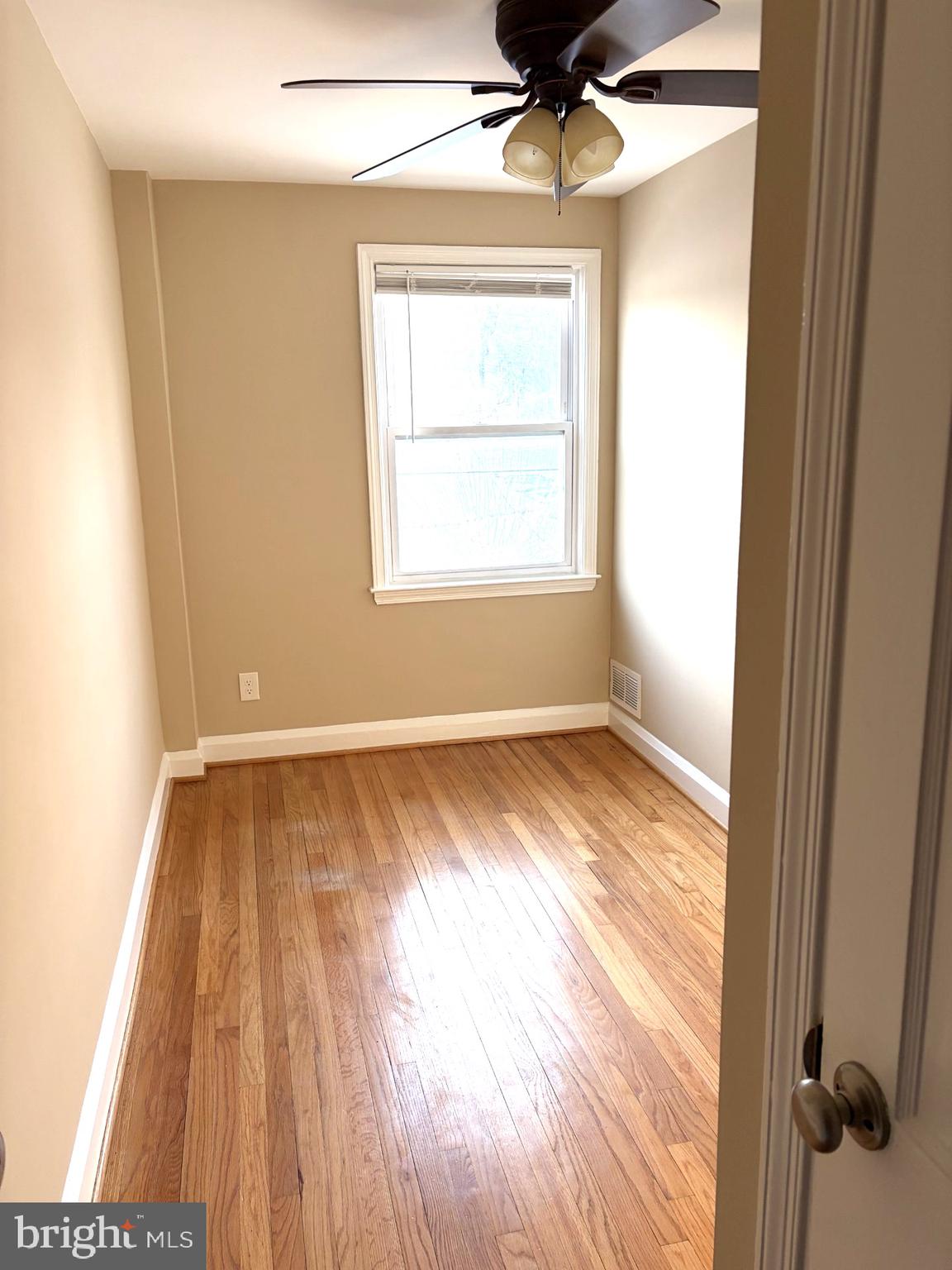 586 Lucia Avenue Baltimore, MD 21229 - Photo 10 of 14 a view of an empty room with wooden floor and a window
