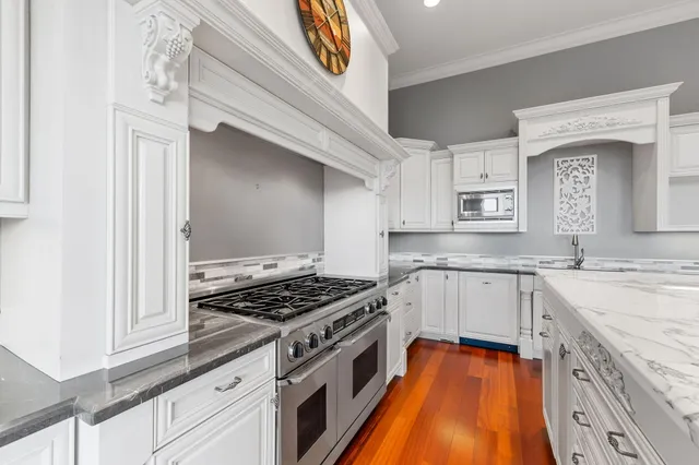 a view of a hallway with wooden floor and a bathroom