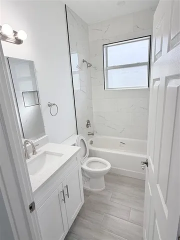a bathroom with a sink a toilet a mirror and shower