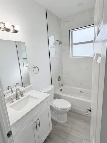 a bathroom with a sink a toilet and a large mirror