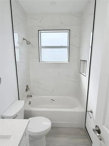 a bathroom with a bathtub shower and a toilet