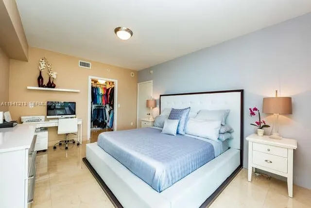 a bedroom with a large bed and a view of living room