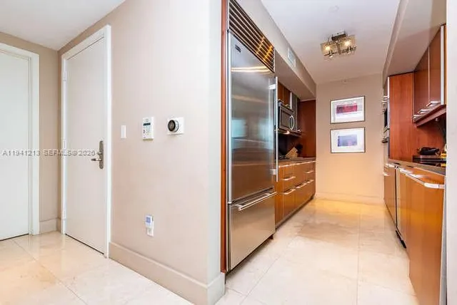 a kitchen with stainless steel appliances granite countertop a refrigerator and a sink