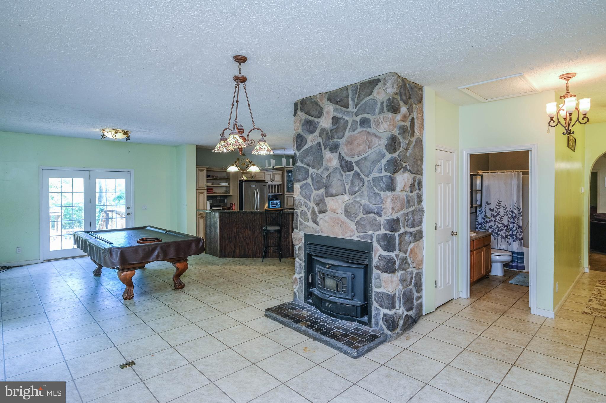 1195 Shangri-La Road Bentonville, VA 22610 - Photo 47 of 64 a living room with furniture a fireplace and a chandelier