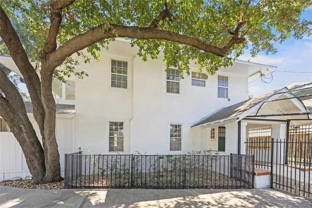 a front view of a house with a tree