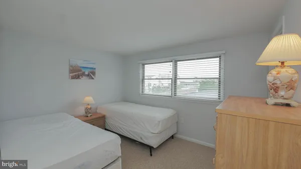 a bedroom with 2 bed and a window
