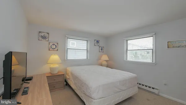 a bedroom with a bed a mirror and a window