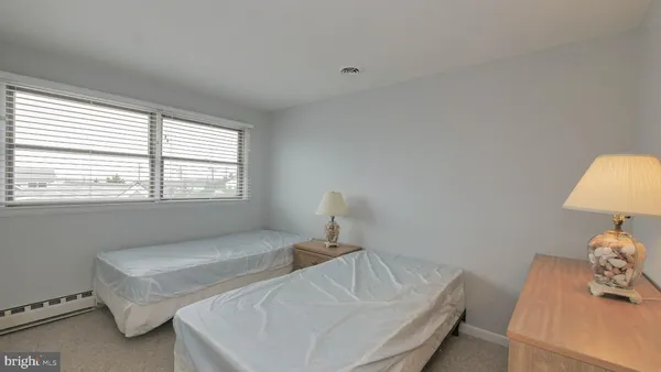 a bedroom with a bed and window with lamp