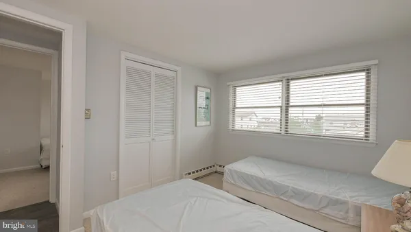 a bedroom with a bed a window and dresser