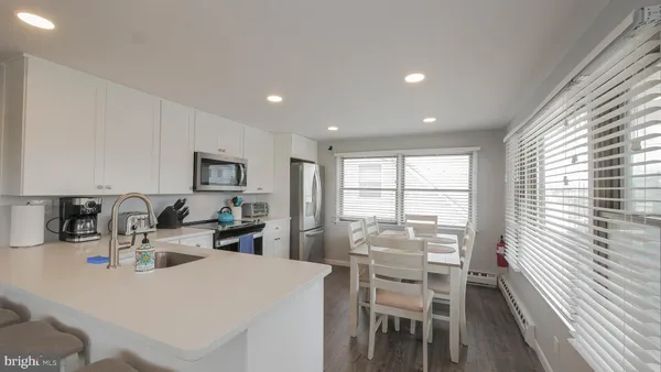 a kitchen with a dining table chairs and white cabinets