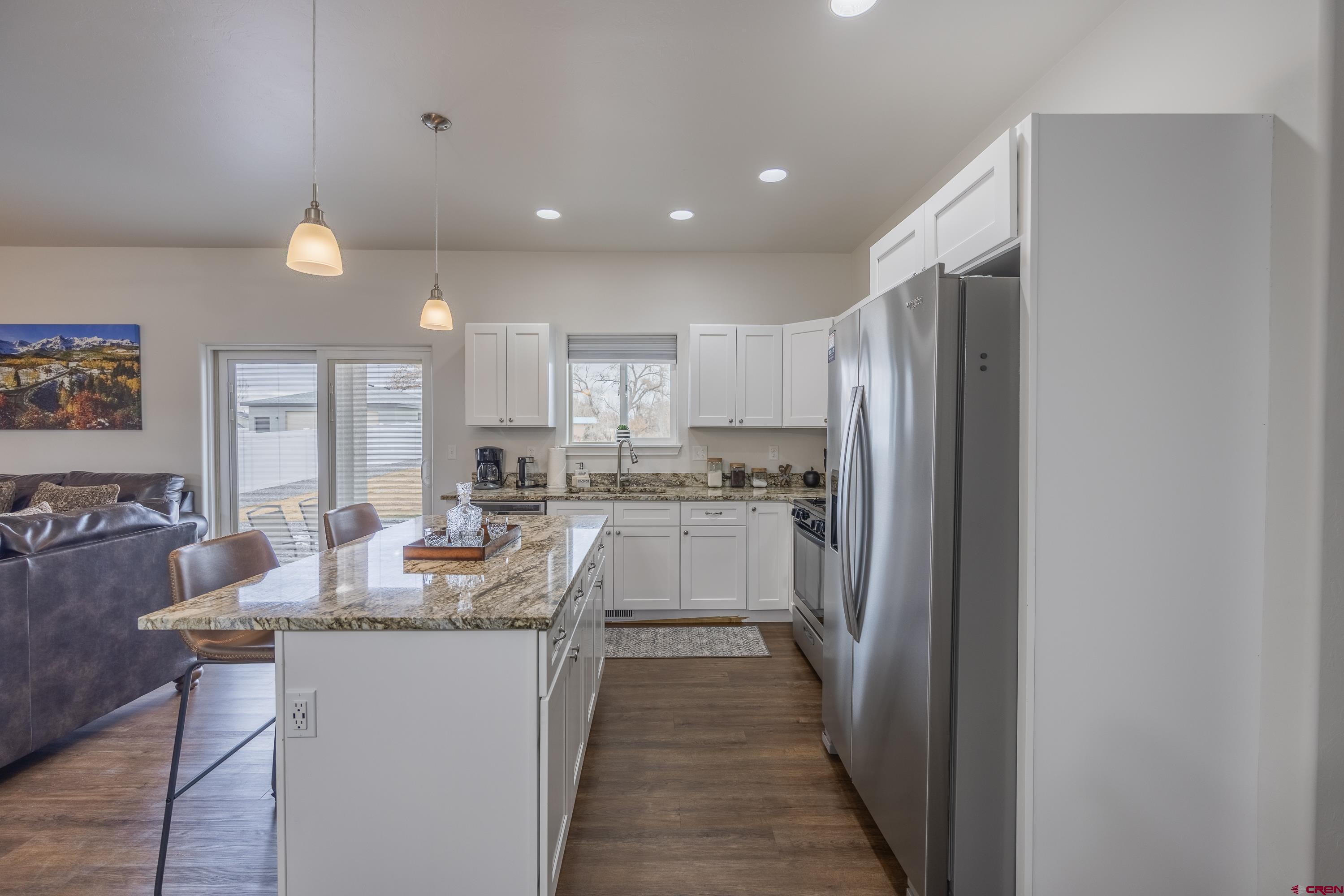 1725 Moonlight Drive Montrose, CO 81401 - Photo 12 of 35 a kitchen with kitchen island granite countertop appliances cabinets and a counter top space