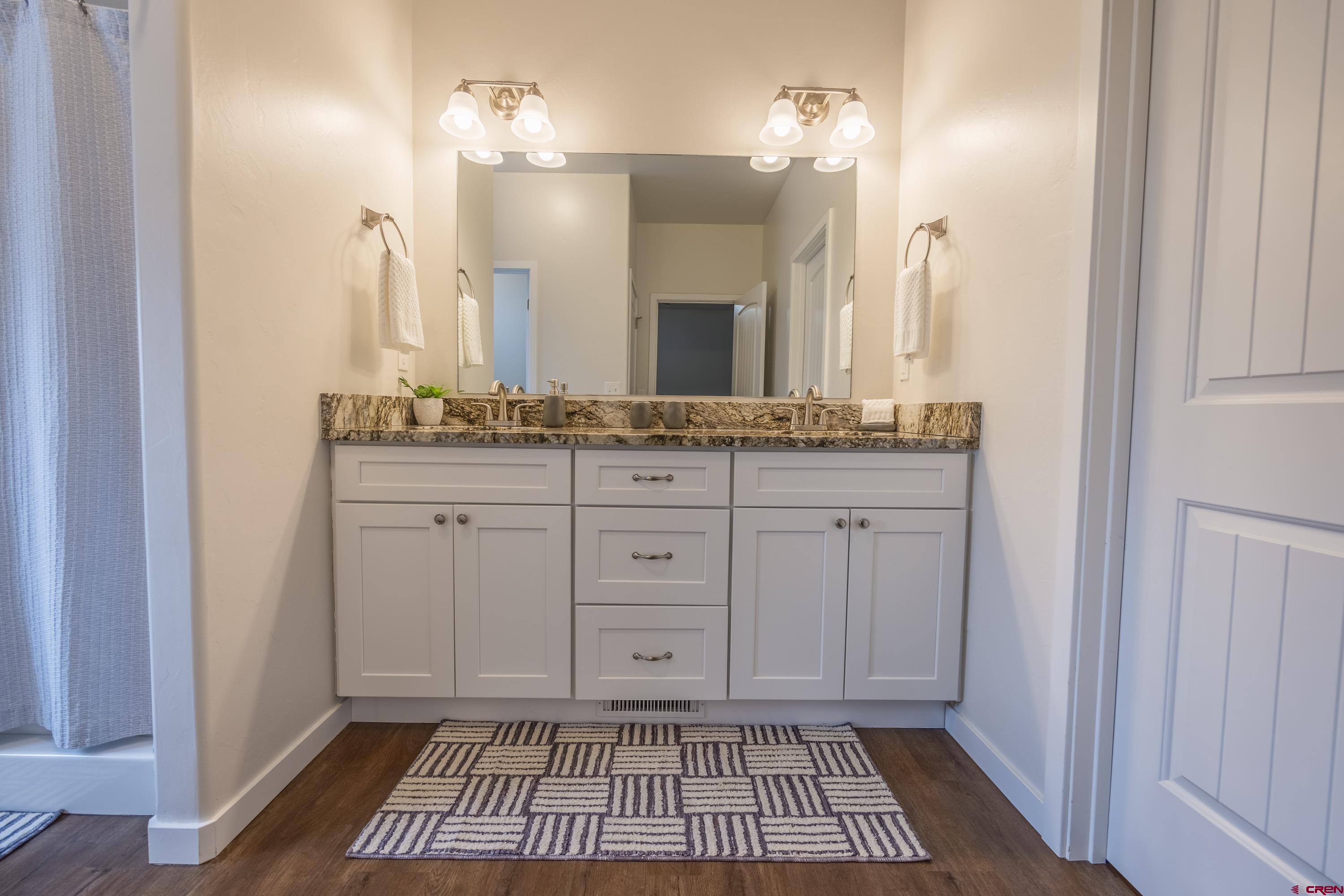 1725 Moonlight Drive Montrose, CO 81401 - Photo 20 of 35 a spacious bathroom with a granite countertop sink a mirror and a vanity