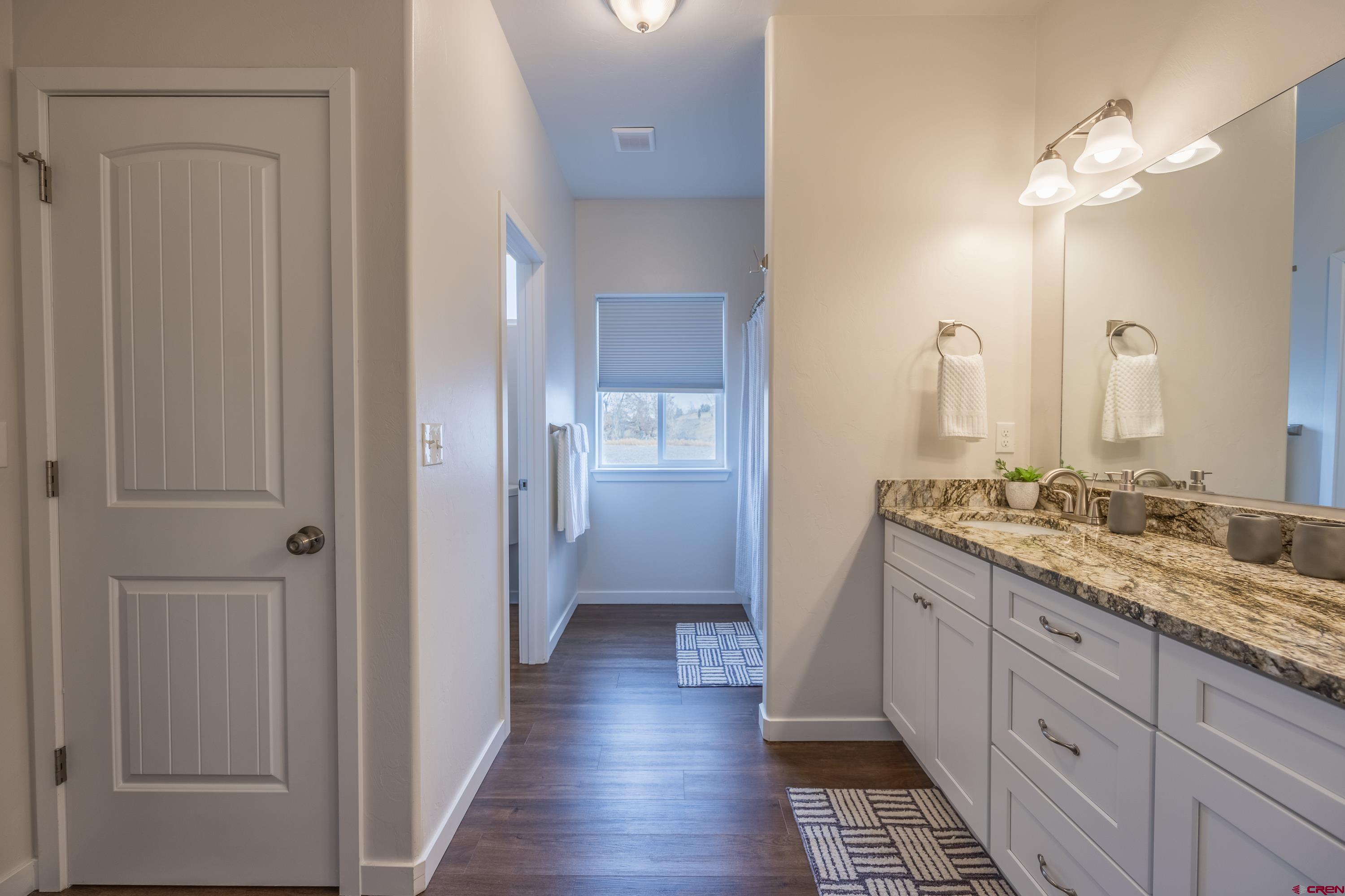 1725 Moonlight Drive Montrose, CO 81401 - Photo 21 of 35 a bathroom with a double vanity sink and a mirror
