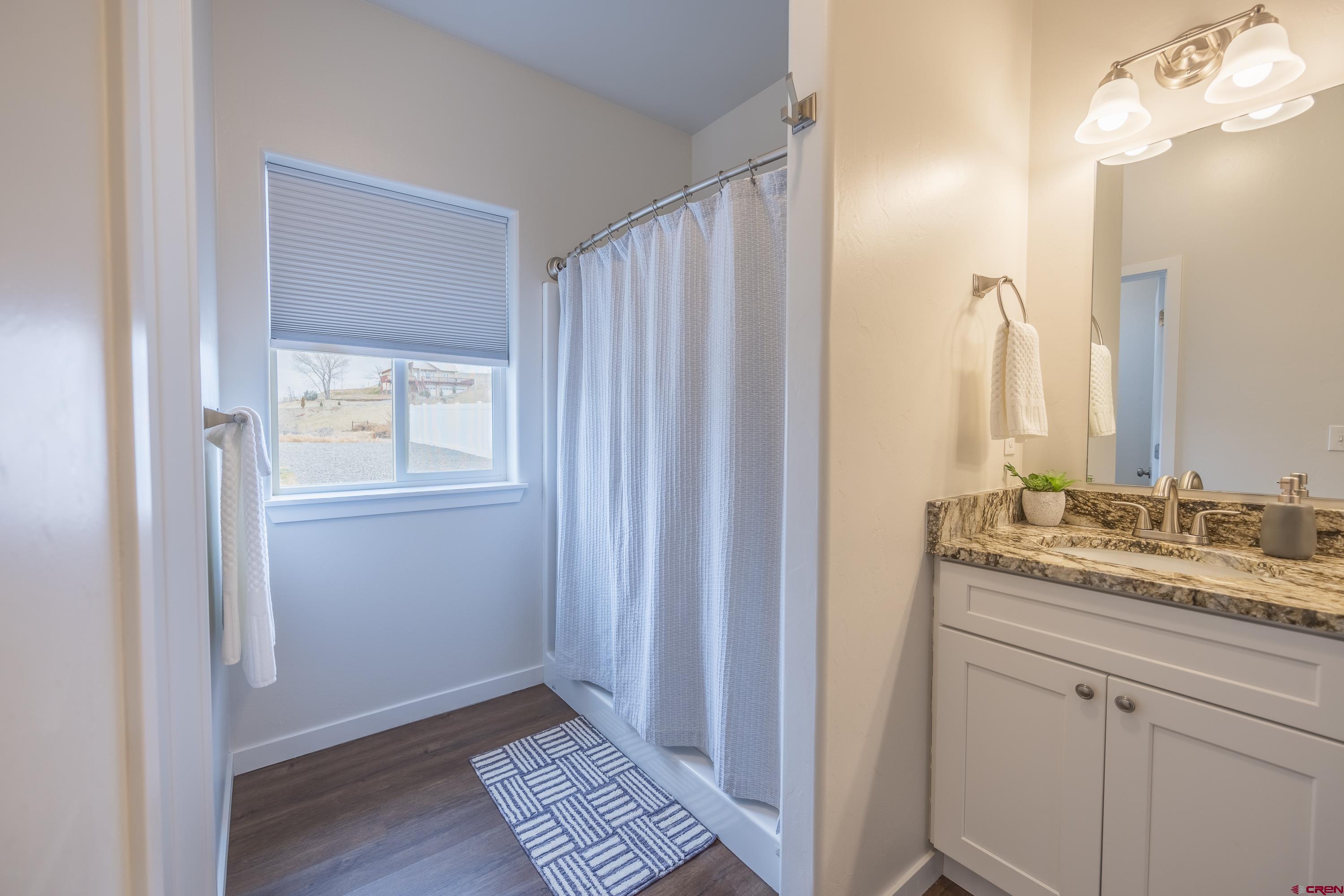 1725 Moonlight Drive Montrose, CO 81401 - Photo 22 of 35 a bathroom with a granite countertop sink and a mirror