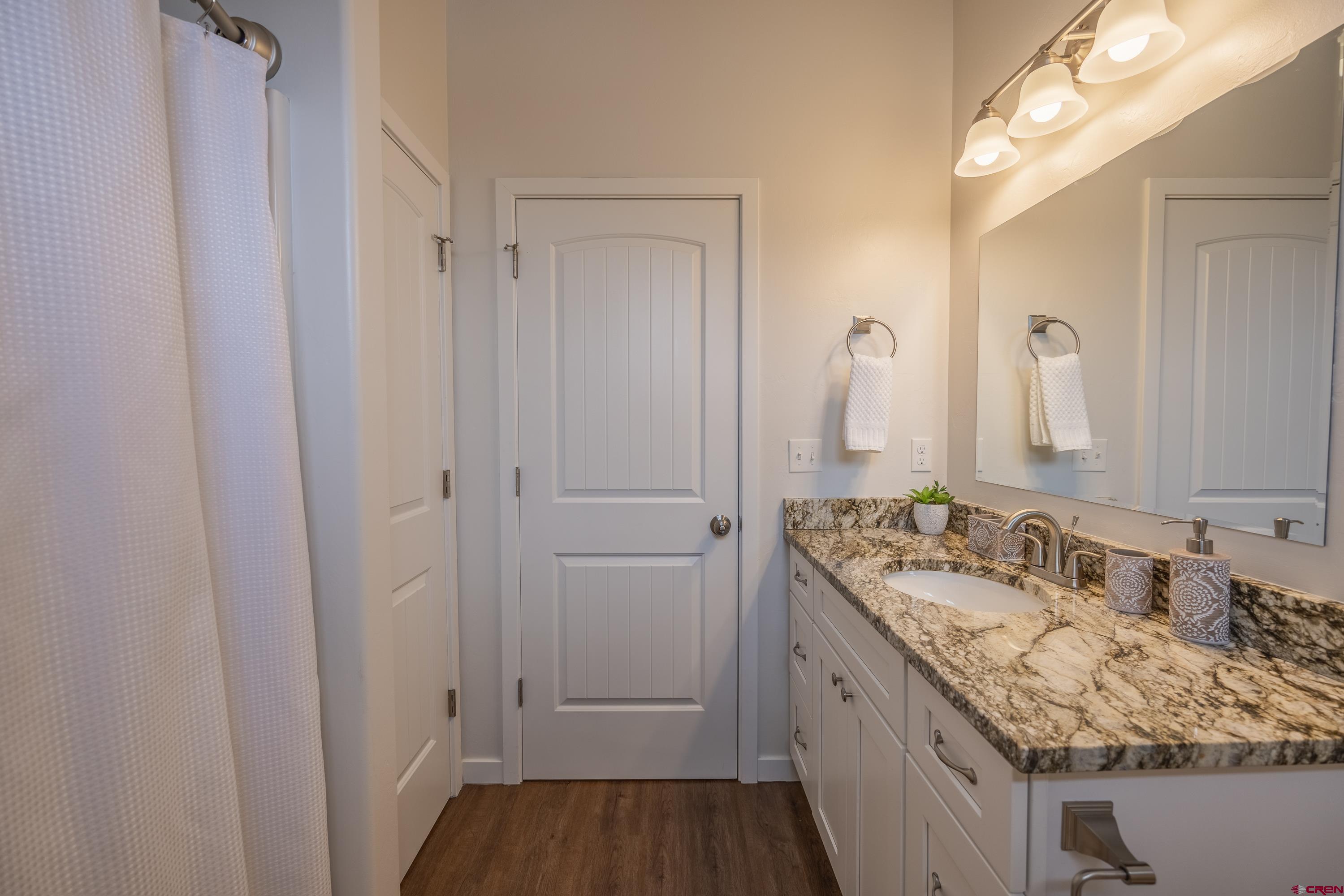 1725 Moonlight Drive Montrose, CO 81401 - Photo 28 of 35 a bathroom with a granite countertop sink and a mirror