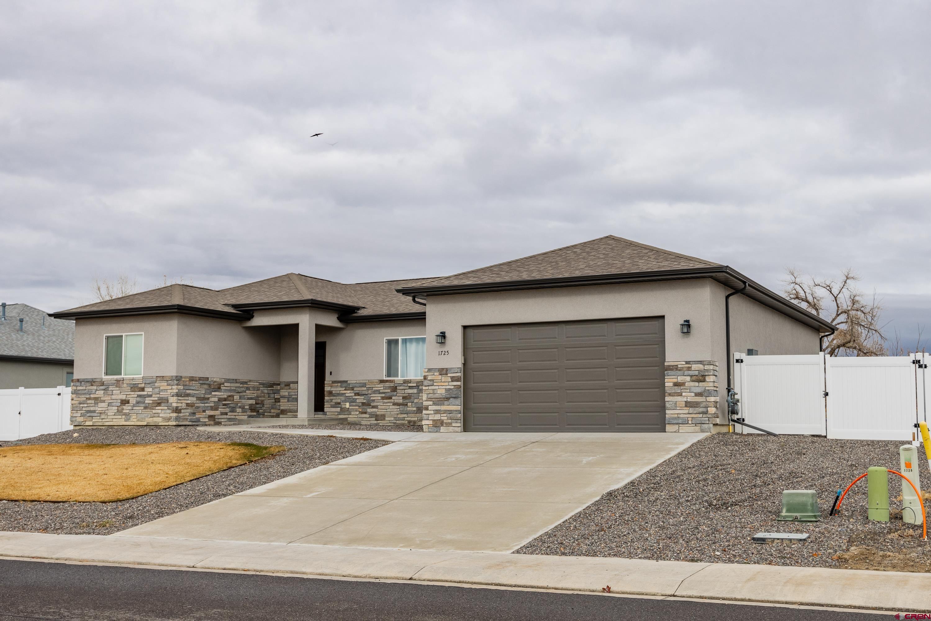 1725 Moonlight Drive Montrose, CO 81401 - Photo 3 of 35 a front view of a house with a yard and garage