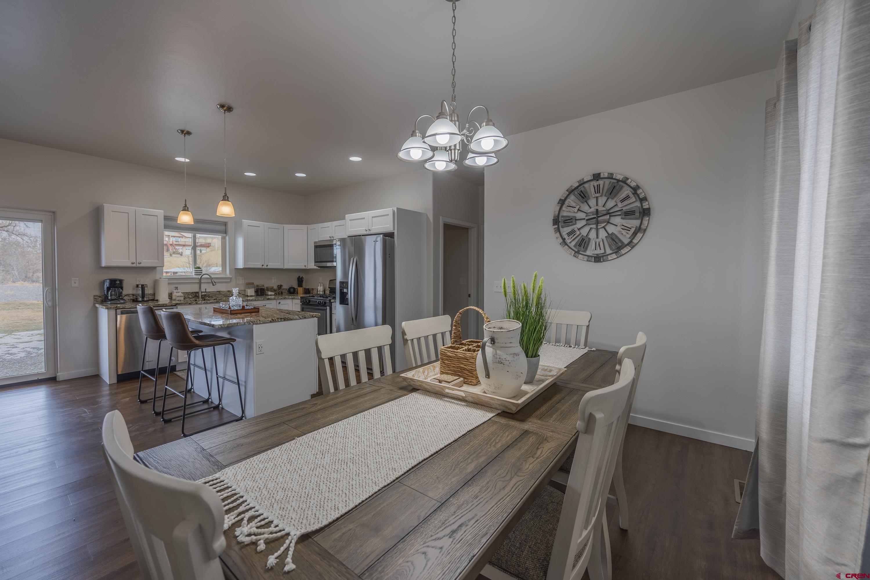 1725 Moonlight Drive Montrose, CO 81401 - Photo 10 of 35 a view of a dining room with furniture a chandelier and wooden floor