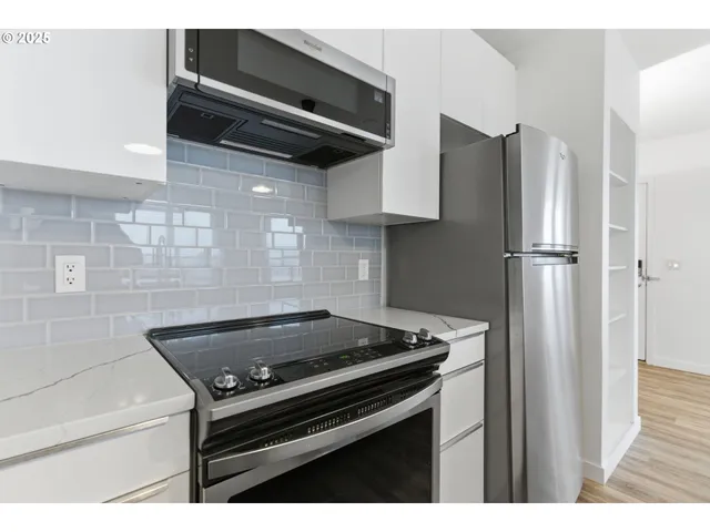 a kitchen with stainless steel appliances granite countertop a refrigerator and a stove