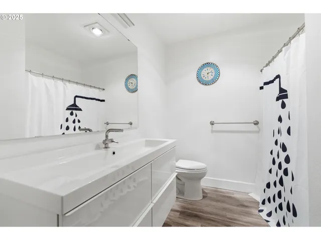 a bathroom with a sink a toilet a shower and a mirror