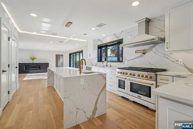 a living room with stainless steel appliances furniture and a kitchen view