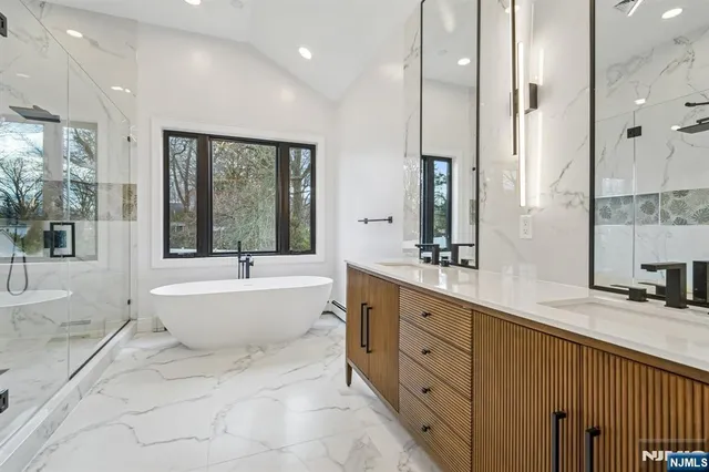 a spacious bathroom with a double vanity sink large mirror and a bathtub