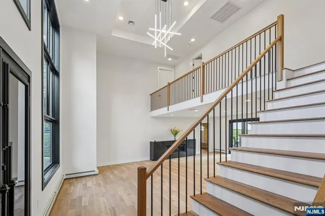 a view of staircase with wooden floor and a chandelier
