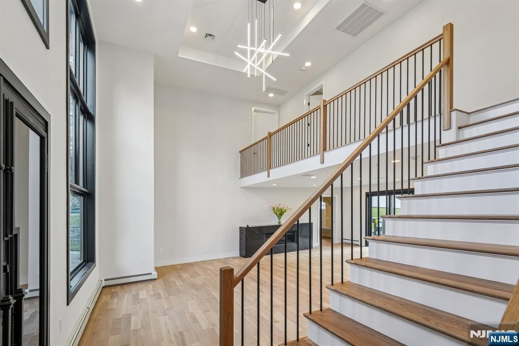 292 Magnolia Avenue Cresskill, NJ 07626 - Photo 7 of 50 a view of staircase with wooden floor and a chandelier