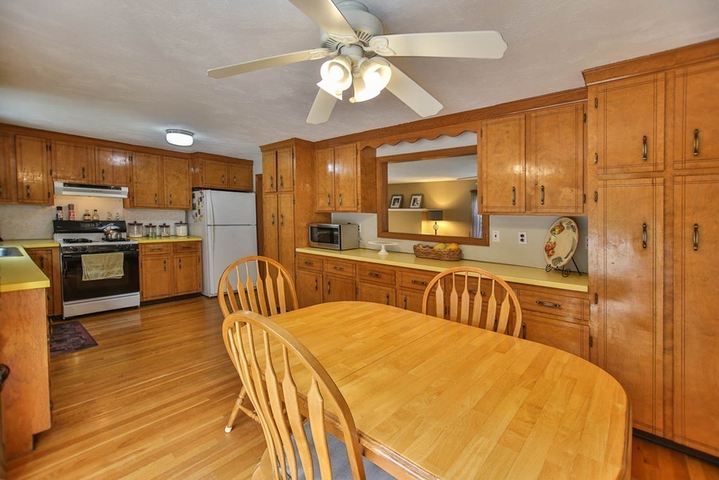 15 Town Line Road Burlington, MA 01803 - Photo 6 of 27 a large kitchen with kitchen island granite countertop a stove a sink a refrigerator dining table and chairs with wooden floor