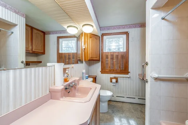 a bathroom with a sink a toilet and mirror