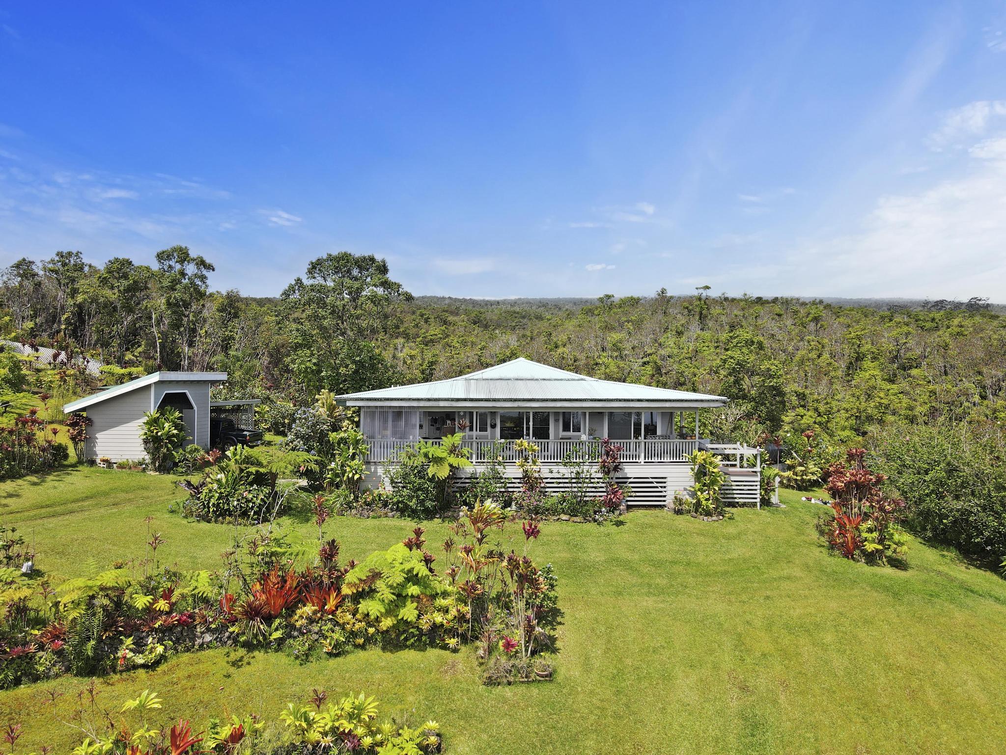 a view of a big house with a big yard and potted plants