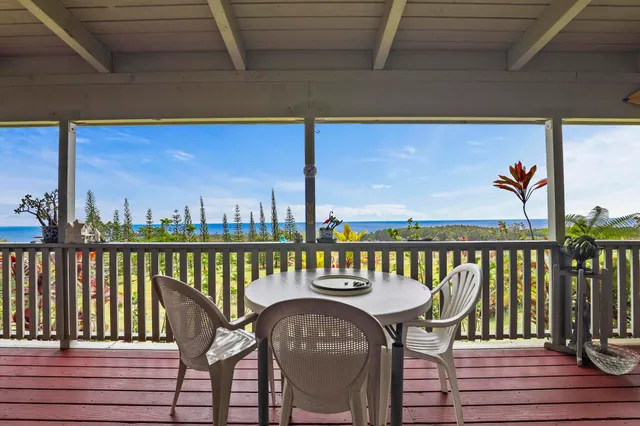 a view of a balcony with chairs and wooden floor