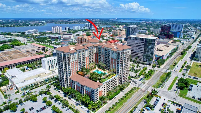 a front view of a building with glass windows and a yard