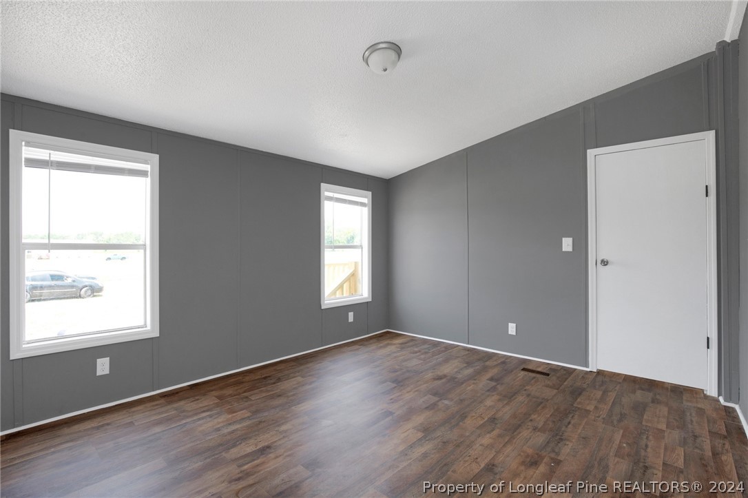 152 Three Bridges Road Rowland, NC 28383 - Photo 13 of 27 a view of an empty room with wooden floor and a window