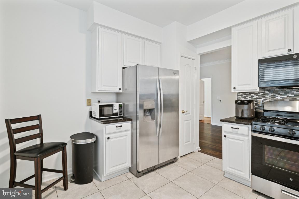 20903 Cedarpost Square, Unit 101 Ashburn, VA 20147 - Photo 11 of 26 a kitchen with stainless steel appliances granite countertop a stove a refrigerator and a refrigerator