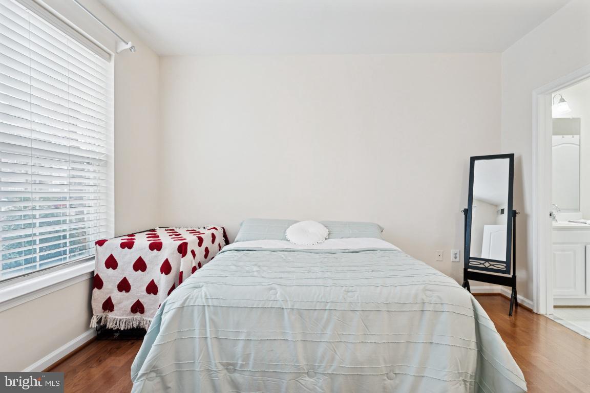 20903 Cedarpost Square, Unit 101 Ashburn, VA 20147 - Photo 13 of 26 a bedroom with a bed and wooden floor