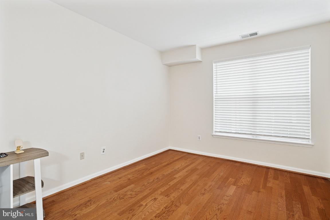 20903 Cedarpost Square, Unit 101 Ashburn, VA 20147 - Photo 17 of 26 a view of an empty room with wooden floor and a window