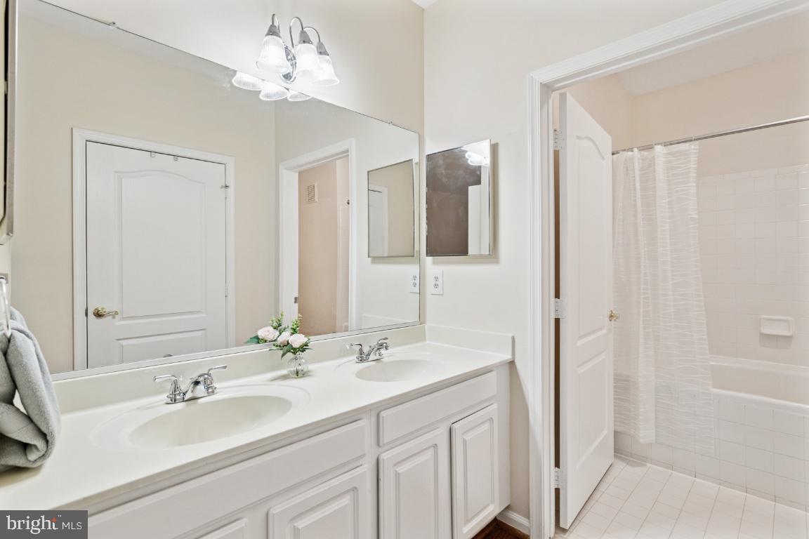 20903 Cedarpost Square, Unit 101 Ashburn, VA 20147 - Photo 19 of 26 a bathroom with a double vanity sink and a mirror