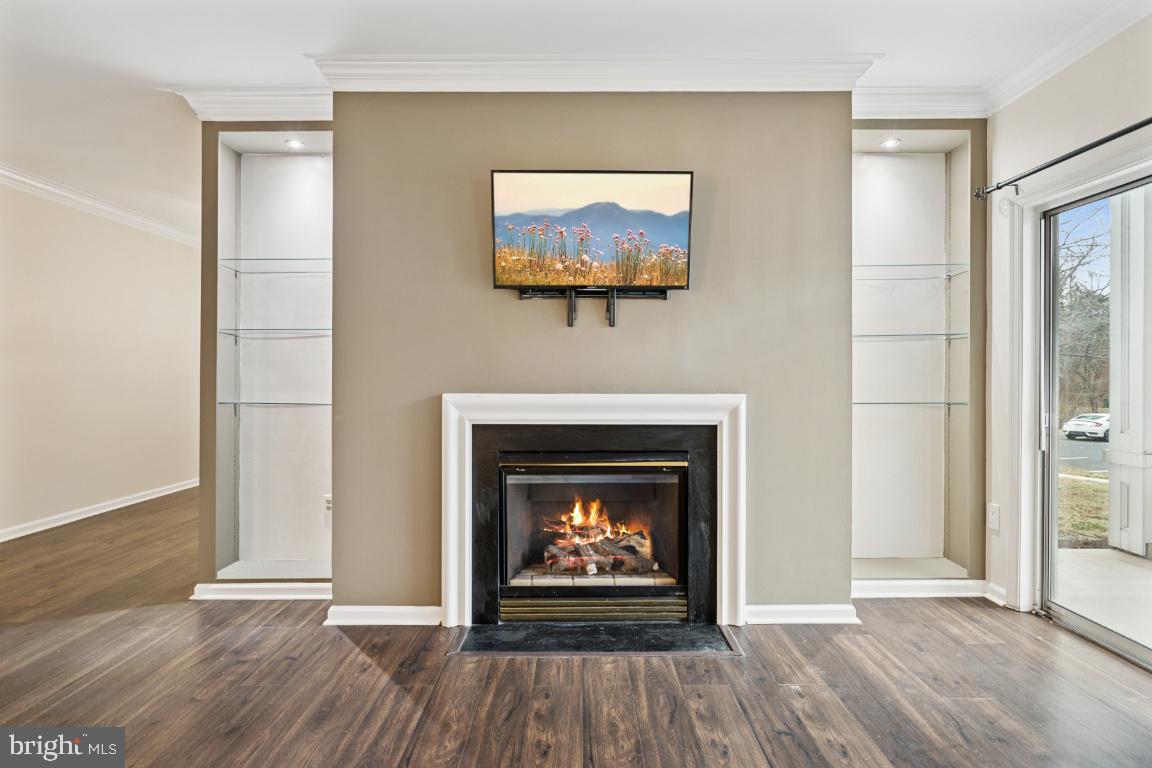 20903 Cedarpost Square, Unit 101 Ashburn, VA 20147 - Photo 3 of 26 an empty room with wooden floor fireplace and windows