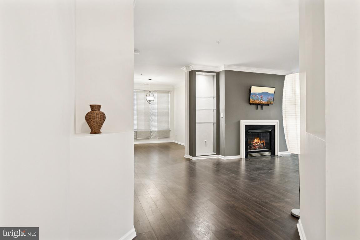 20903 Cedarpost Square, Unit 101 Ashburn, VA 20147 - Photo 4 of 26 a view of an empty room with wooden floor and fireplace