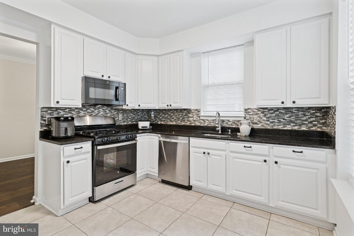 20903 Cedarpost Square, Unit 101 Ashburn, VA 20147 - Photo 9 of 26 a kitchen with granite countertop white cabinets and stainless steel appliances