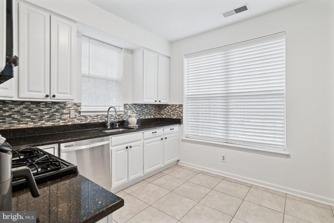 20903 Cedarpost Square, Unit 101 Ashburn, VA 20147 - Photo 10 of 26 a kitchen with granite countertop white cabinets and white appliances