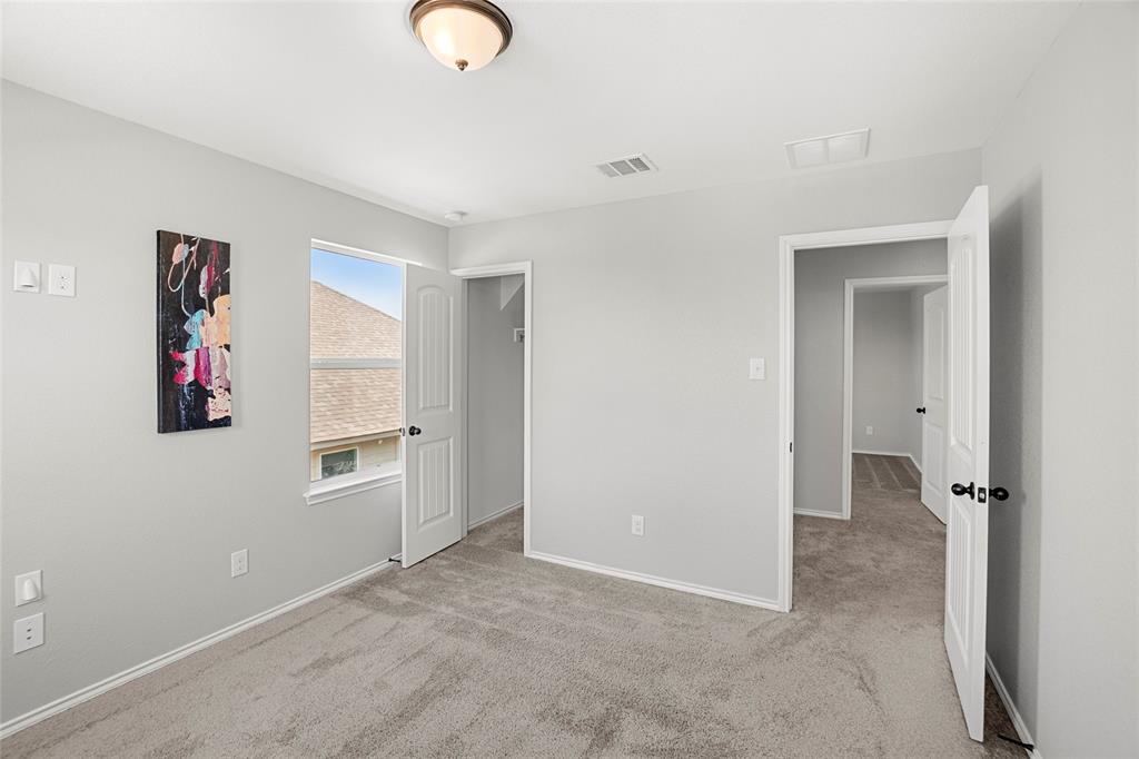 117 West Point Way Elgin, TX 78621 - Photo 9 of 21 Plush carpeting and crisp white trim enhance this serene upper-level bedroom.