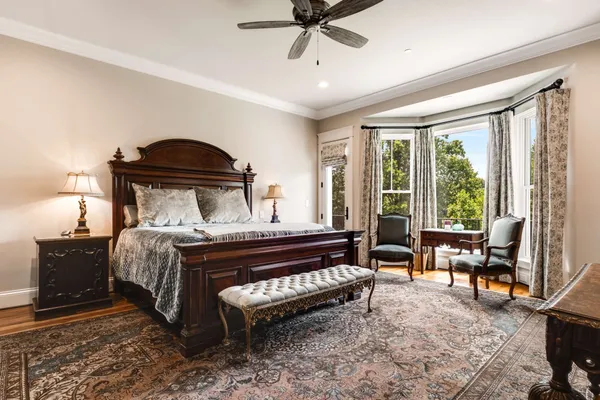 a bed sitting in a spacious bedroom next to a window