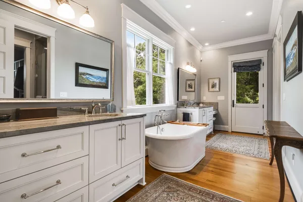 a spacious bathroom with a double vanity sink a mirror and a bathtub