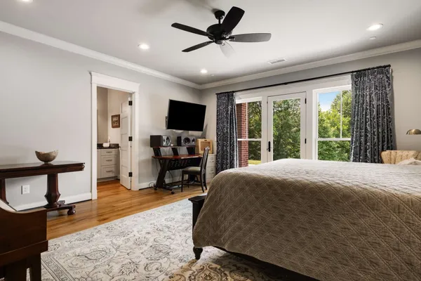 a bedroom with a bed a chandelier and a flat screen tv